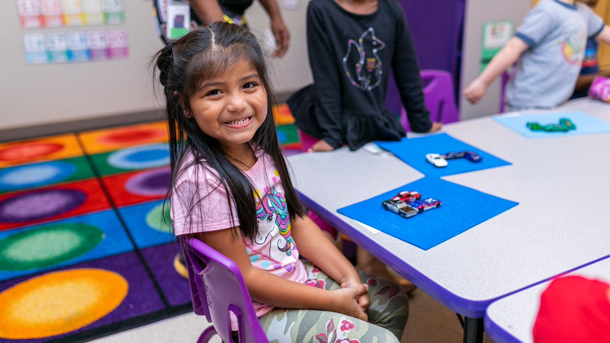 child sitting at table in preschool setting